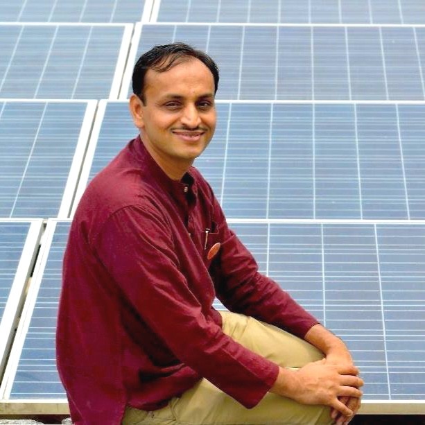 The Solar Man of India posing beside solar panels | Global Indian