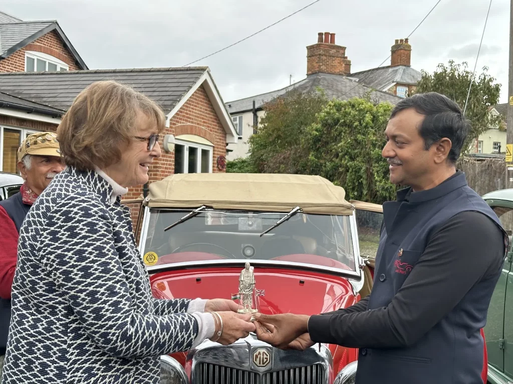 Daman Thakore handing the statue of Unity to Mrs Felicity Dick